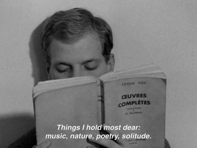 A black and white image of a man reading a book. The text overlay reads "Things I hold most dear: music, nature, poetry, solitude."