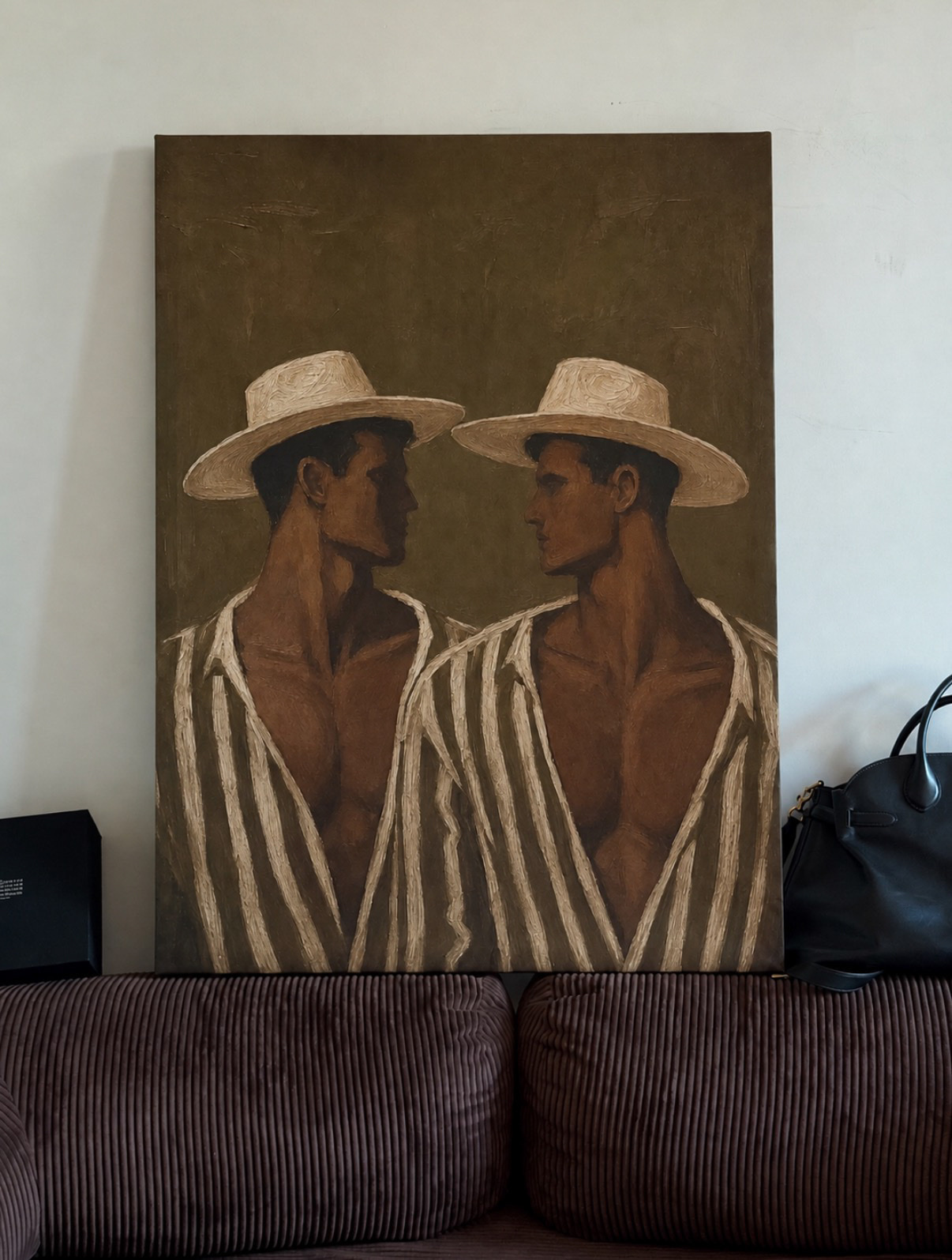 A painting depicts two men wearing straw hats and striped shirts, facing each other. The artwork has a vintage, artistic feel.