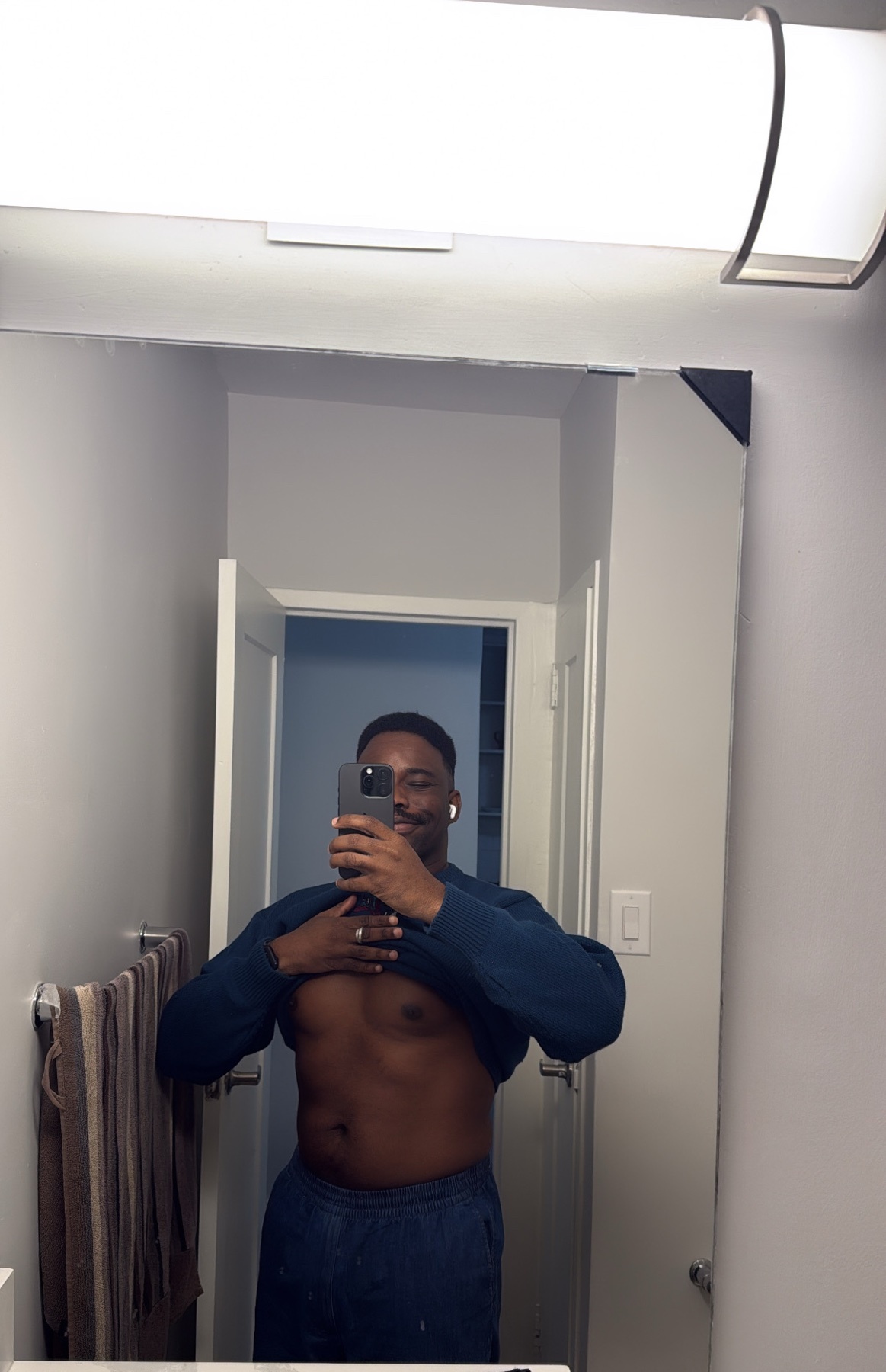 A man takes a mirror selfie, showing off his physique. He is shirtless, with a muscular build.