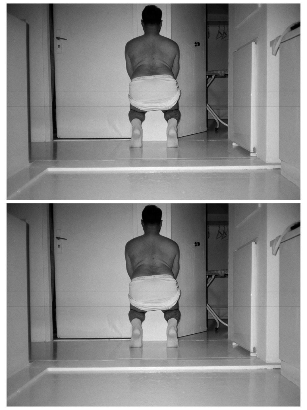 A black and white photo of a man squatting in a hallway, seen from the back. He is shirtless and wearing underwear.