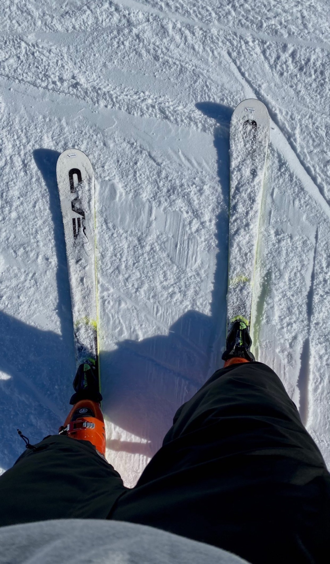 A first-person perspective of skis on a snowy slope. The image captures the skis and boots, ready for a day of skiing.