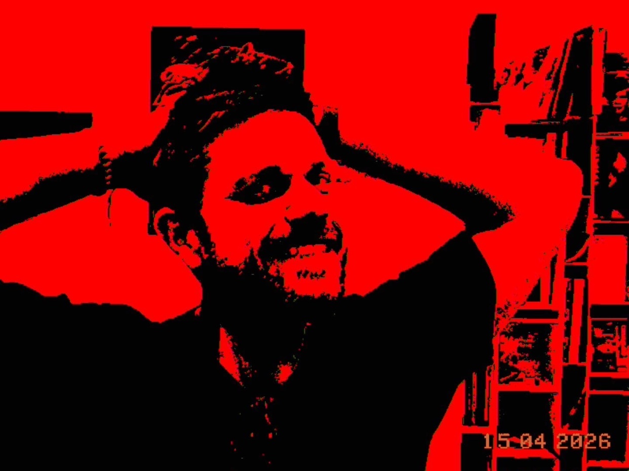 A graphic illustration of a man with his hands in his hair, smiling. The image is predominantly red and black, with a date stamp in the corner.