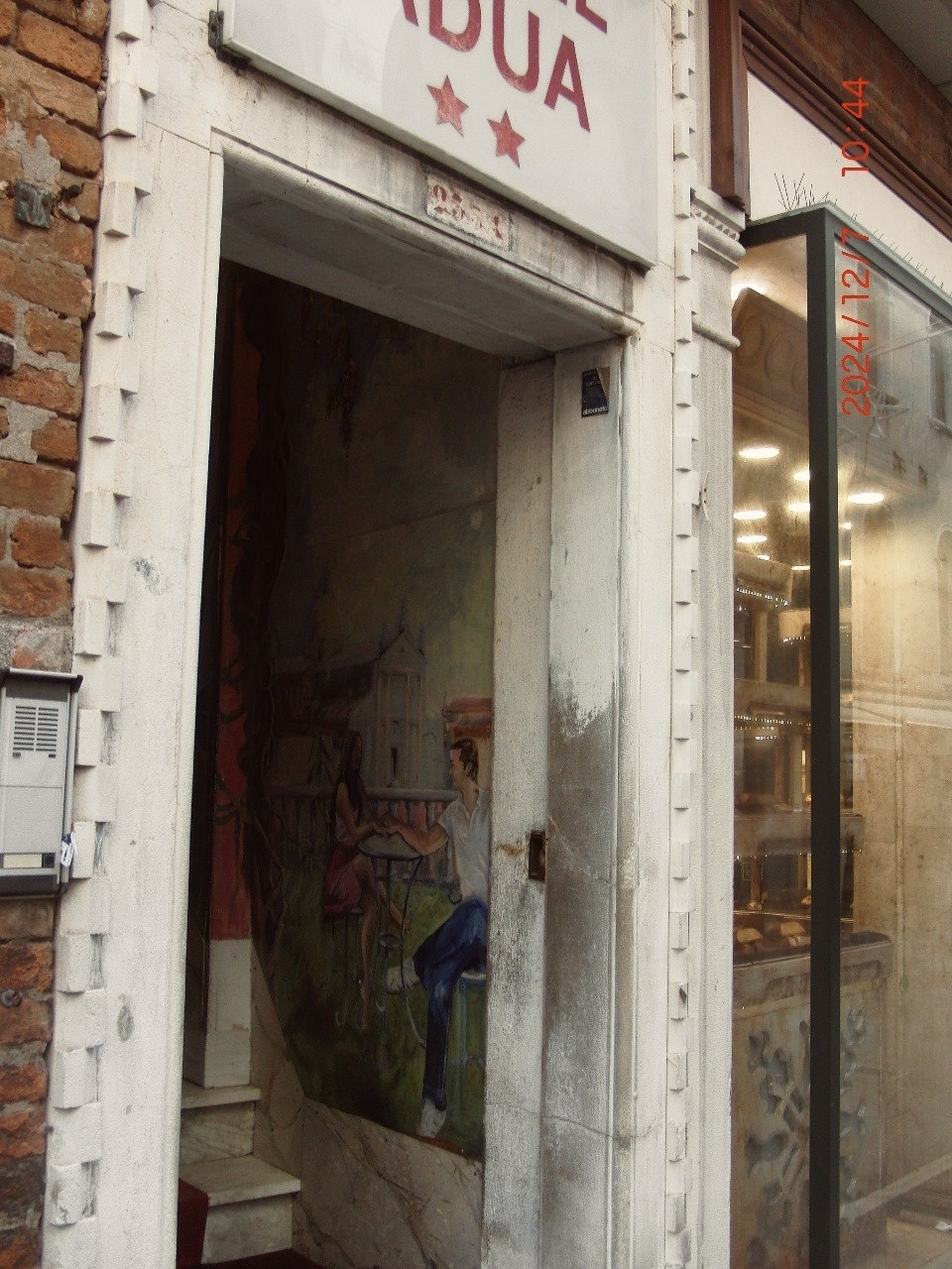 An old building entrance in Venice, Italy. The entrance features a unique design with a mural inside.