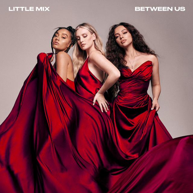 Three women in elegant red gowns are featured on the album cover for Little Mix's 'Between Us'. The flowing fabric of their dresses creates a dramatic and glamorous effect.