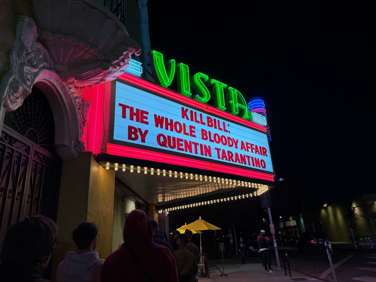 A night shot of the Vista Theatre marquee in Los Angeles, California, advertising a showing of "Kill Bill: The Whole Bloody Affair" by Quentin Tarantino.