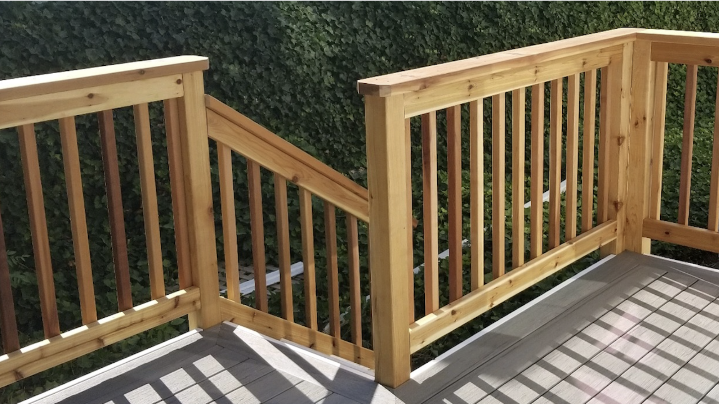 Custom cedar deck rails on grey composit deck