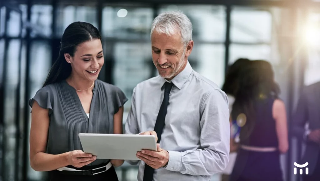 a man and woman looking at a tablet