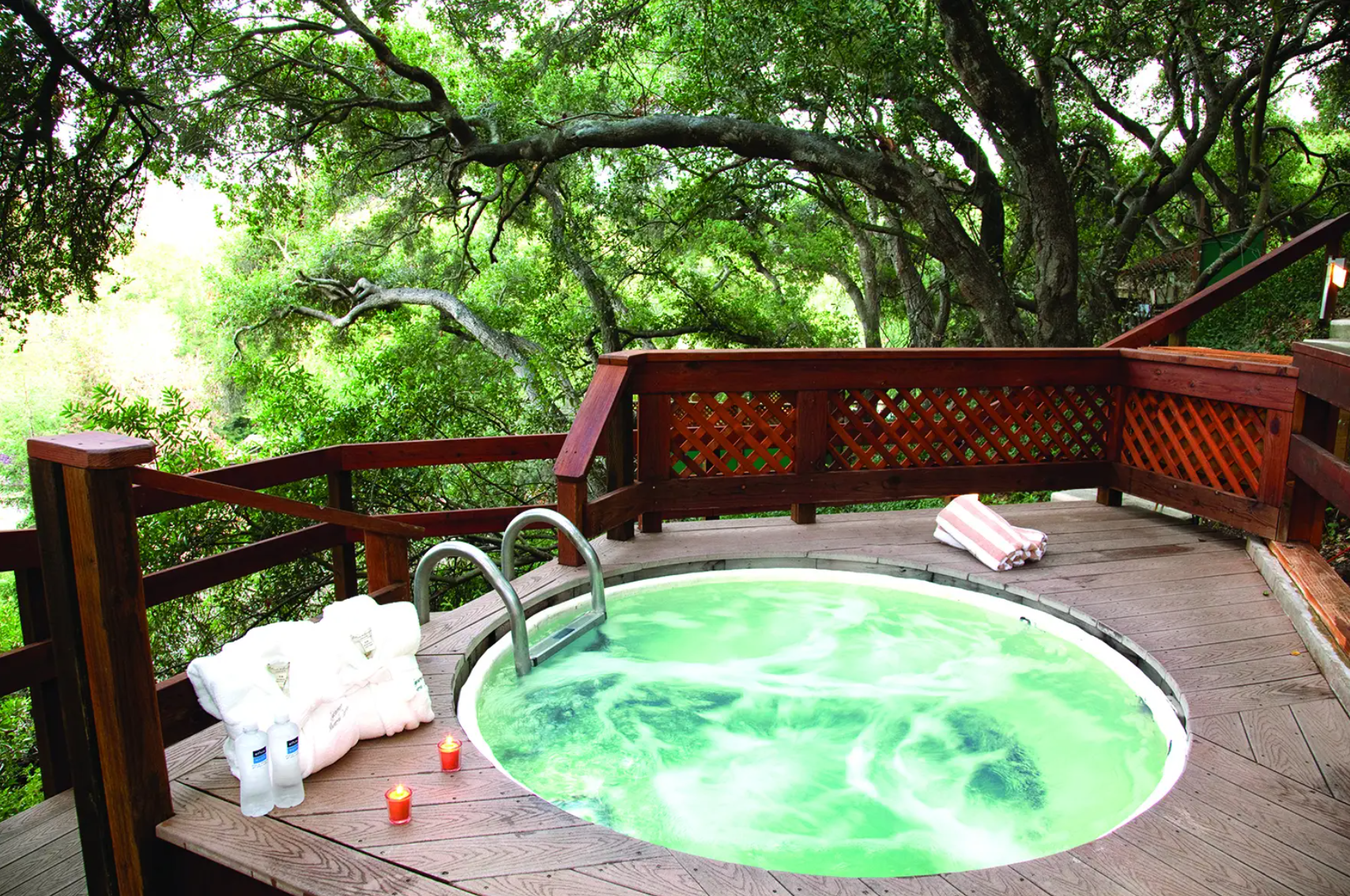 A private mineral soaking tub on a wooden deck under oaks in the Avila Valley
