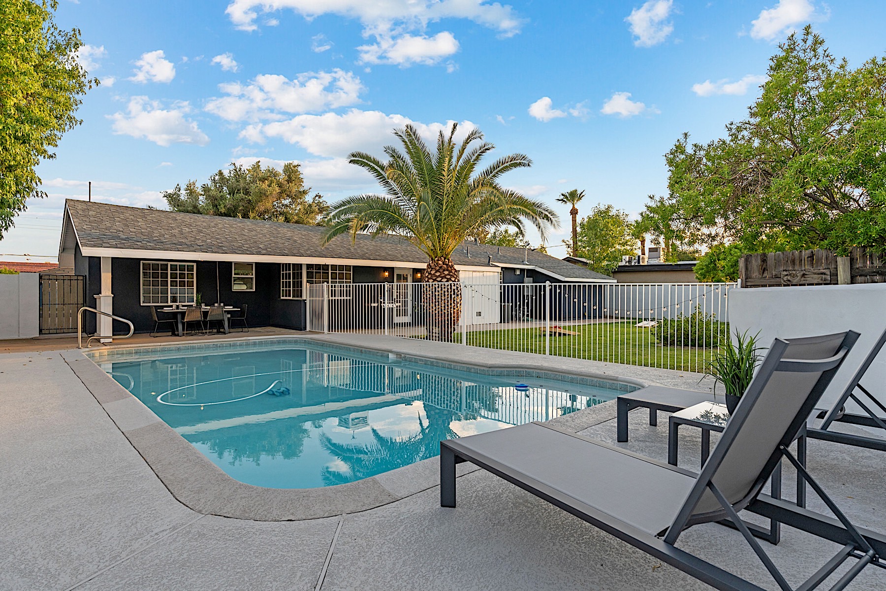 Backyard lawn, diving pool, and loungers at a Casago home in uptown Phoenix