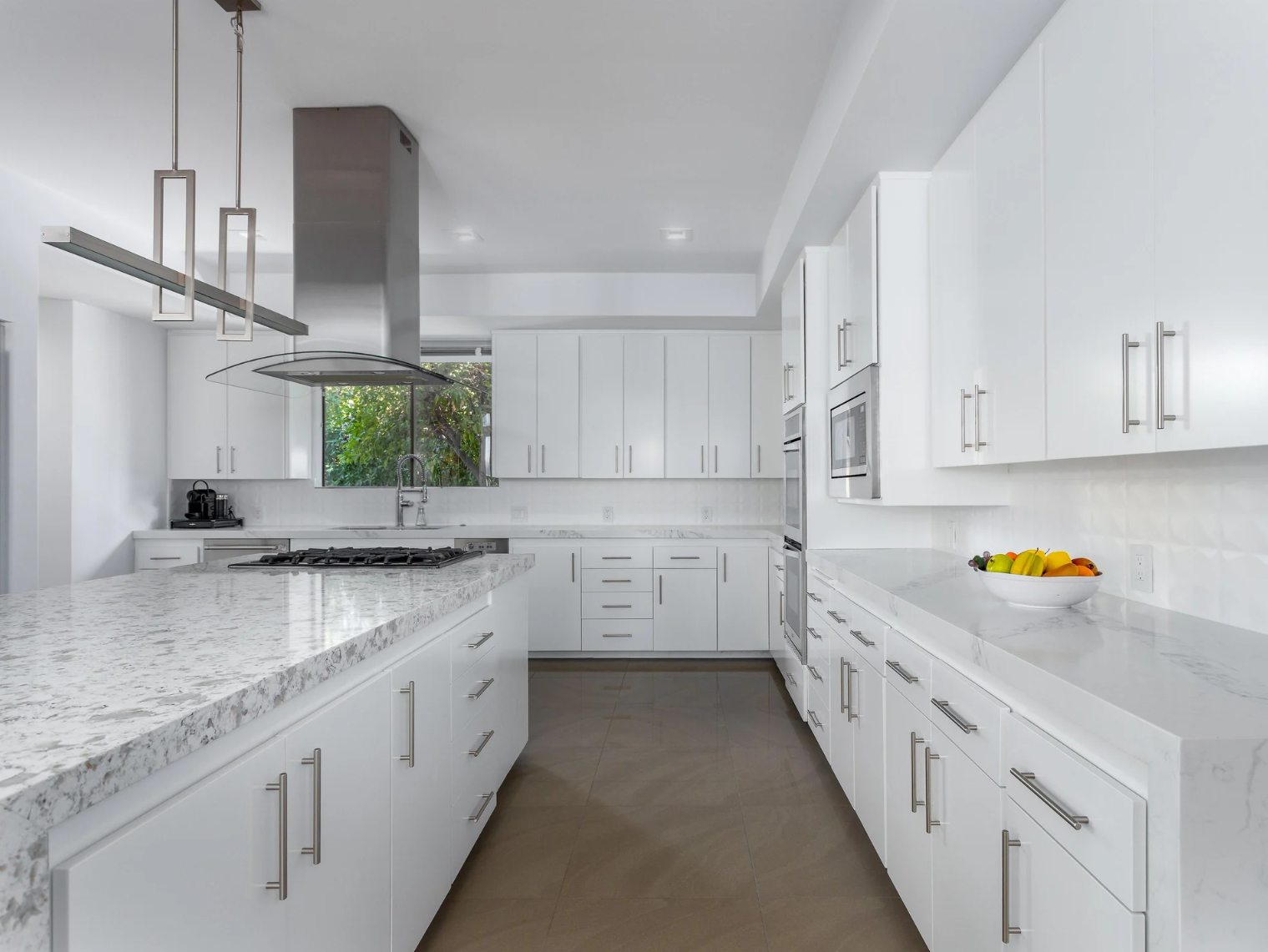 Well-equipped white kitchen with a marble island, gas cooktop and full-size appliances in a Palm Springs vacation rental