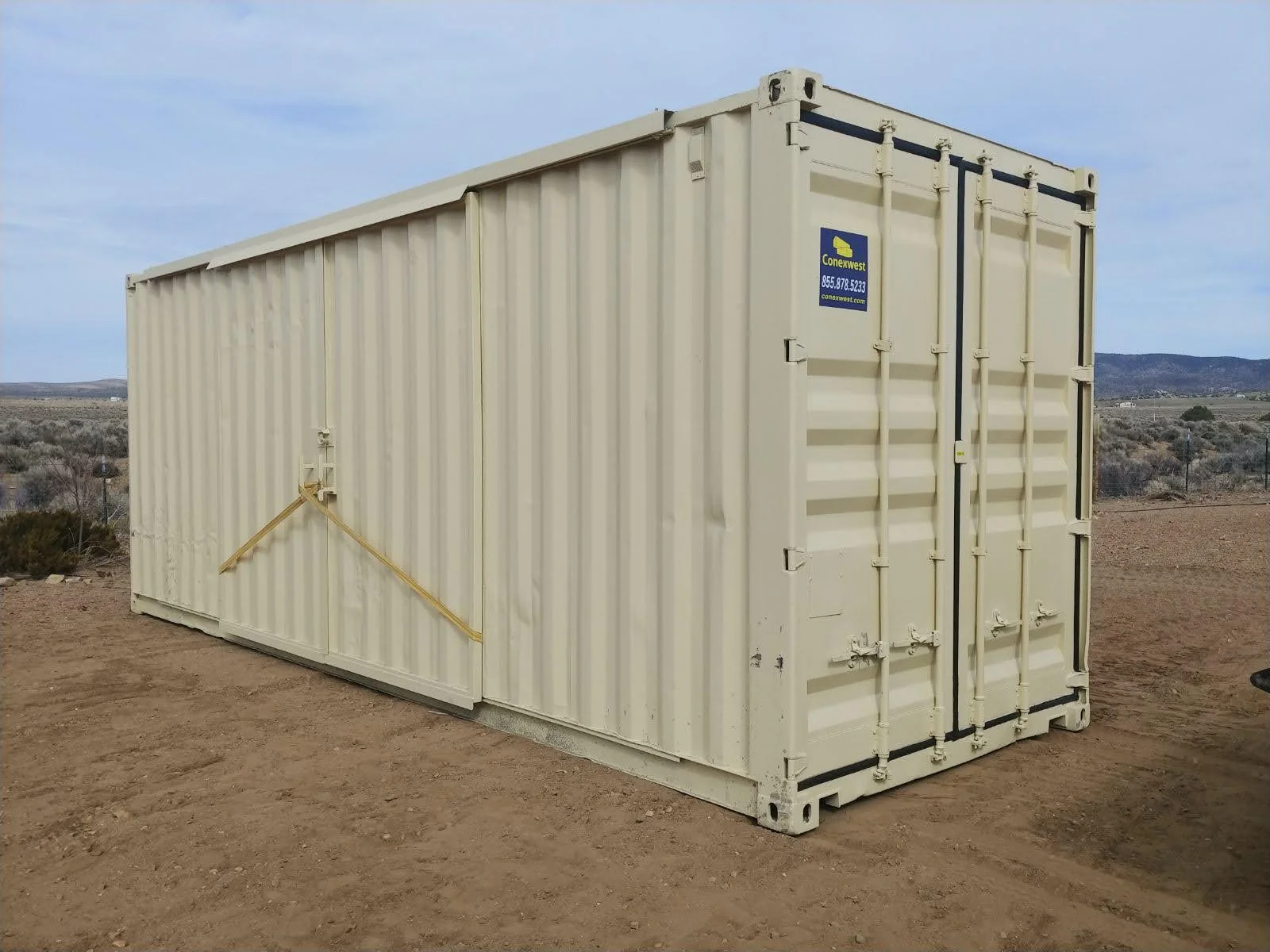 View of a storage container with its barn doors locked and secured with straps