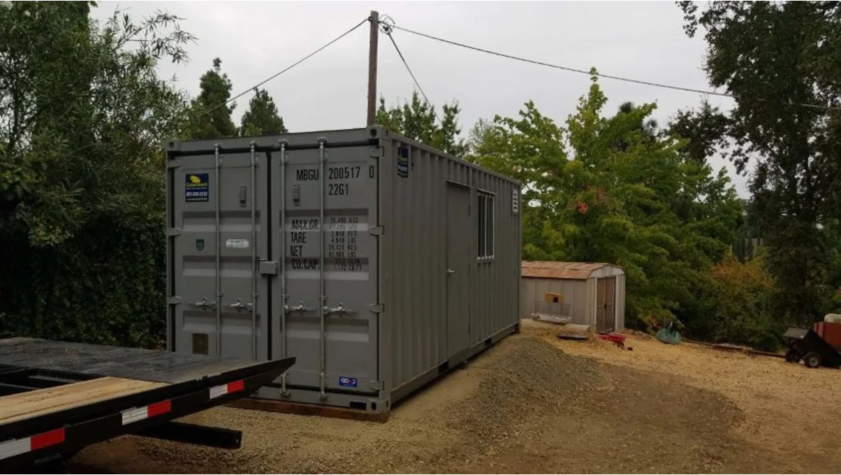 Above-ground shipping container structure as an alternative to full burial