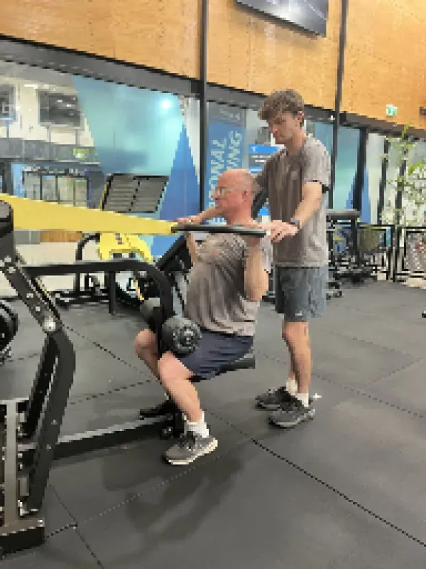 Exercise scientist assisting a client with rehabilitation exercises in a clinical setting