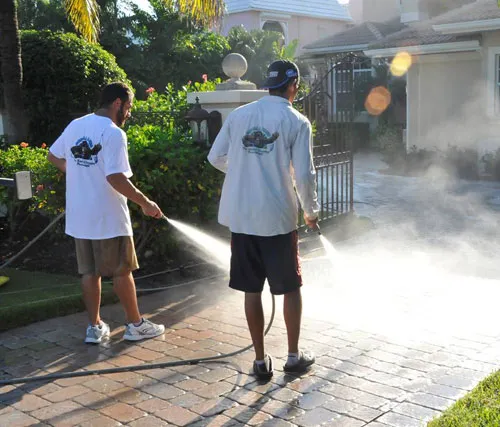 Pressure washer using green cleaning chemicals on a clean driveway