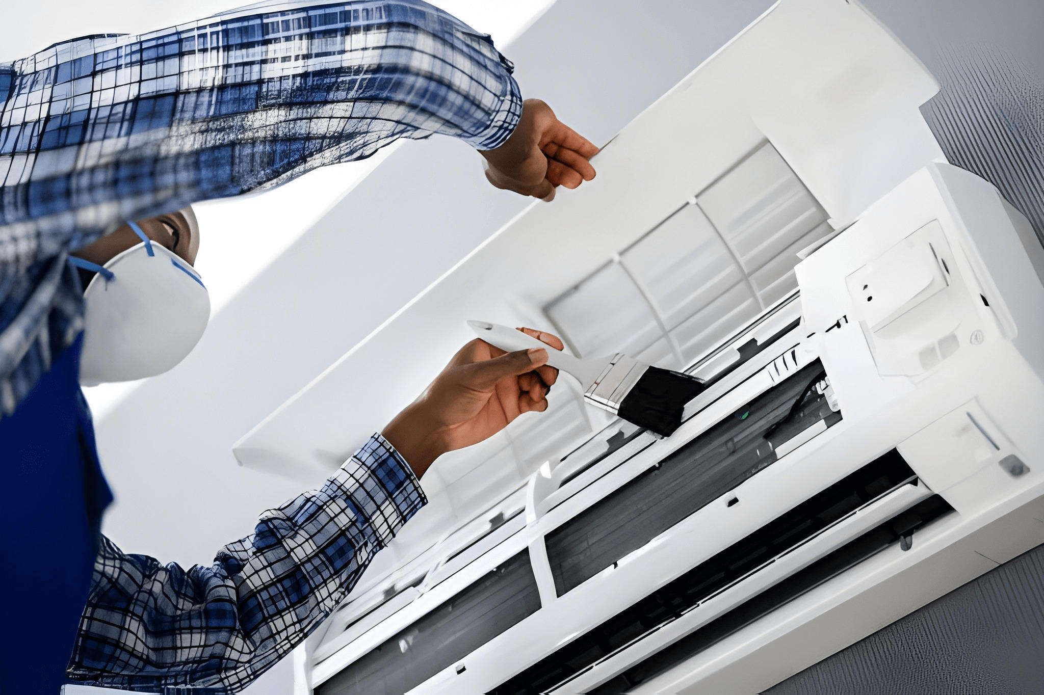 Person cleaning the filter of an air conditioning unit. Person cleaning the filter of an air conditioning unit.