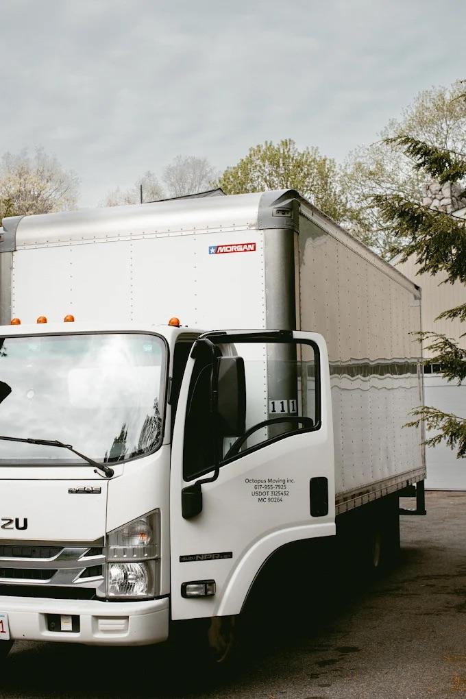 ### Key Elements **Main Subject:** - A large white moving truck. **Objects:** - The truck