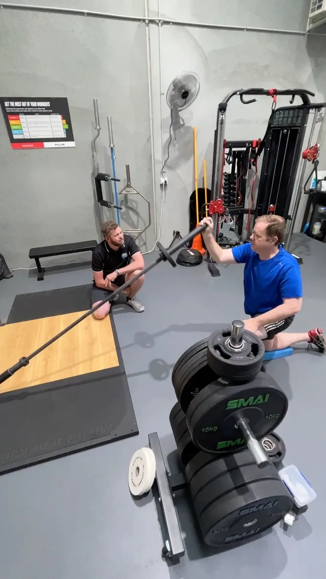 Group of clients and trainer collaborating on fitness goals in a supportive studio environment