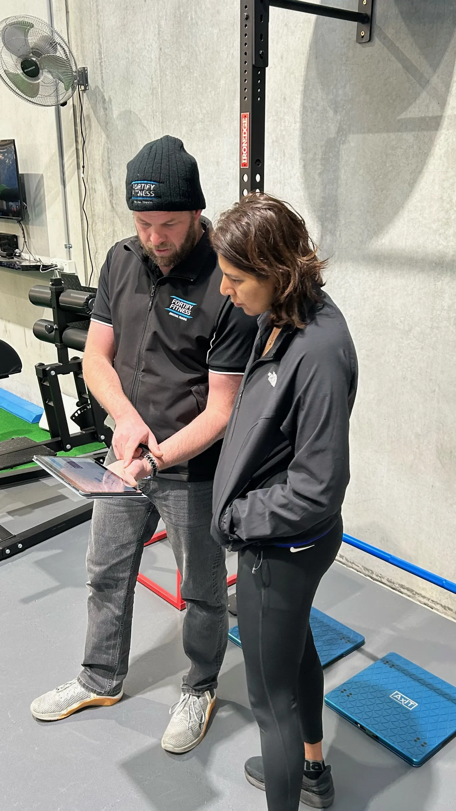 Exercise scientist explaining a personalized fitness program to a client with assessment results