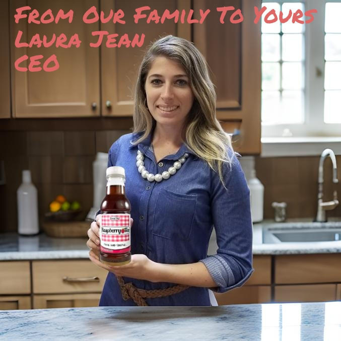 Woman holding raspberry syrup/tea bottle in kitchen