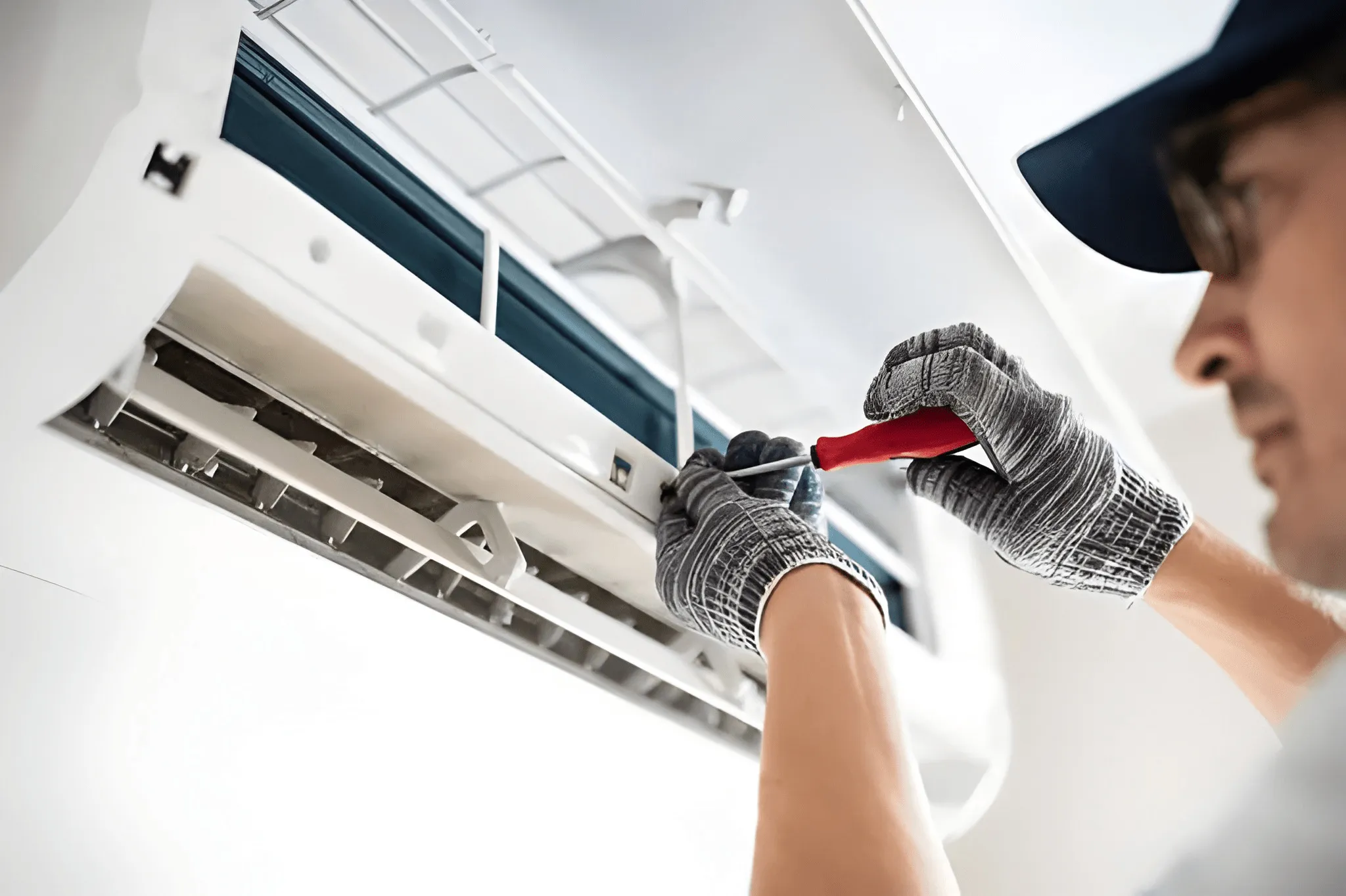 HVAC technician performing AC tune-up and maintenance inspection