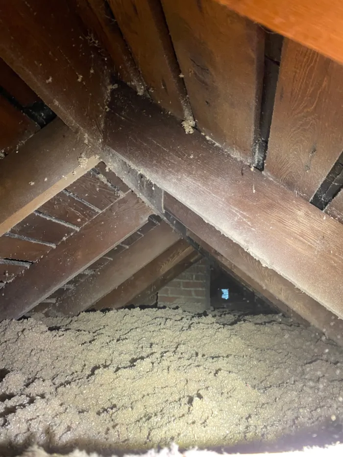 Blown-in fiberglass insulation being installed in a home attic