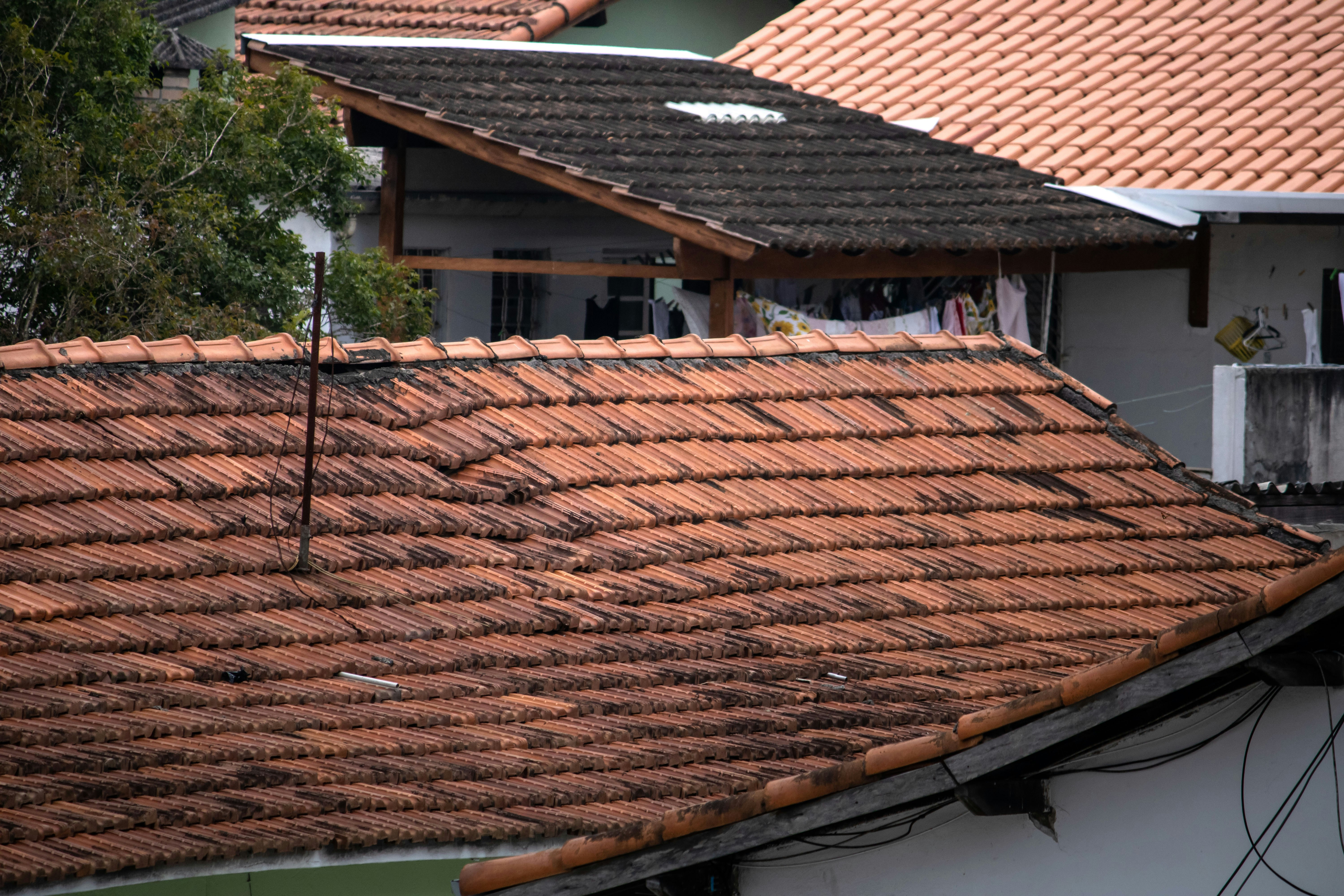Roof with worn and discolored tiles, indicating potential need for repairs or replacement.