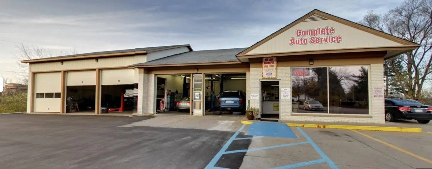 Complete Auto Service building exterior with open garage doors, showcasing a welcoming auto repair shop in Ann Arbor, emphasizing customer convenience and service.