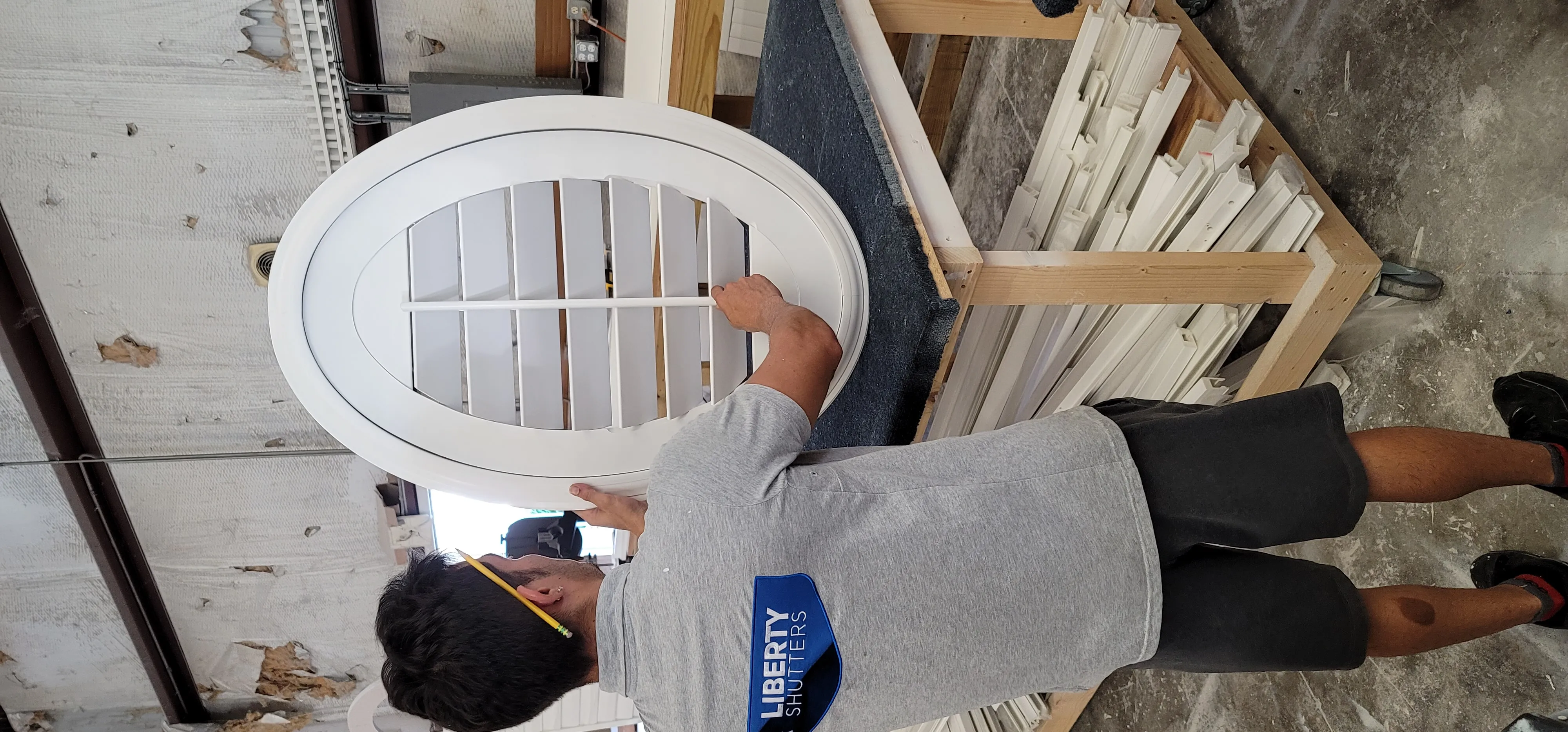 Professional installer preparing custom plantation shutters for installation in a modern home