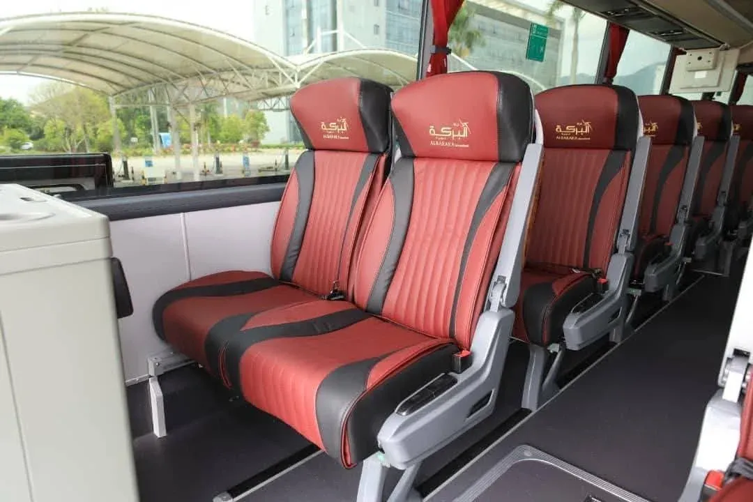 Travel options for Umrah from Riyadh, featuring modern buses and travelers consulting with agents