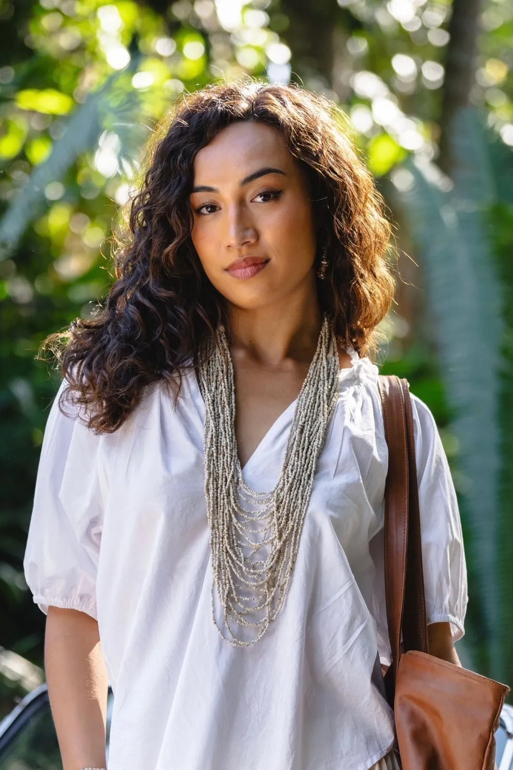 Flat lay of stylish spring accessories including oversized bags and chunky sandals.