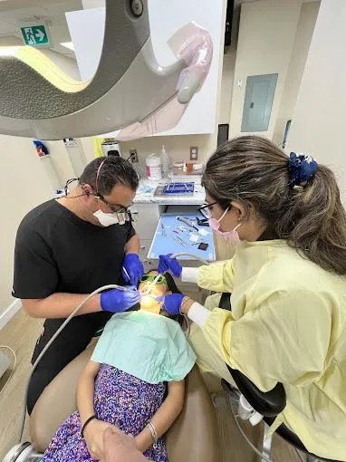 Dentist applying fluoride treatment to a child, showcasing preventive care during dental checkups