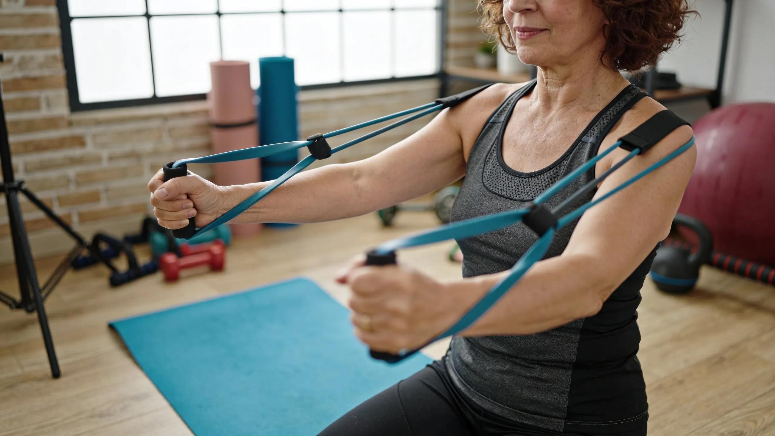 A middle-aged adult practicing safe resistance training techniques with resistance bands at home