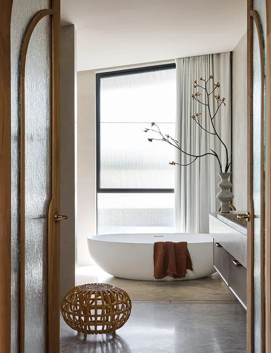 Luxurious IN THE SAC waffle towels elegantly draped over a bathtub in a serene bathroom setting
