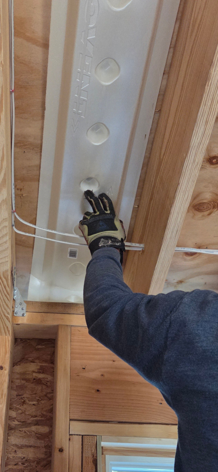 Technician applying spray foam insulation in an older home's attic