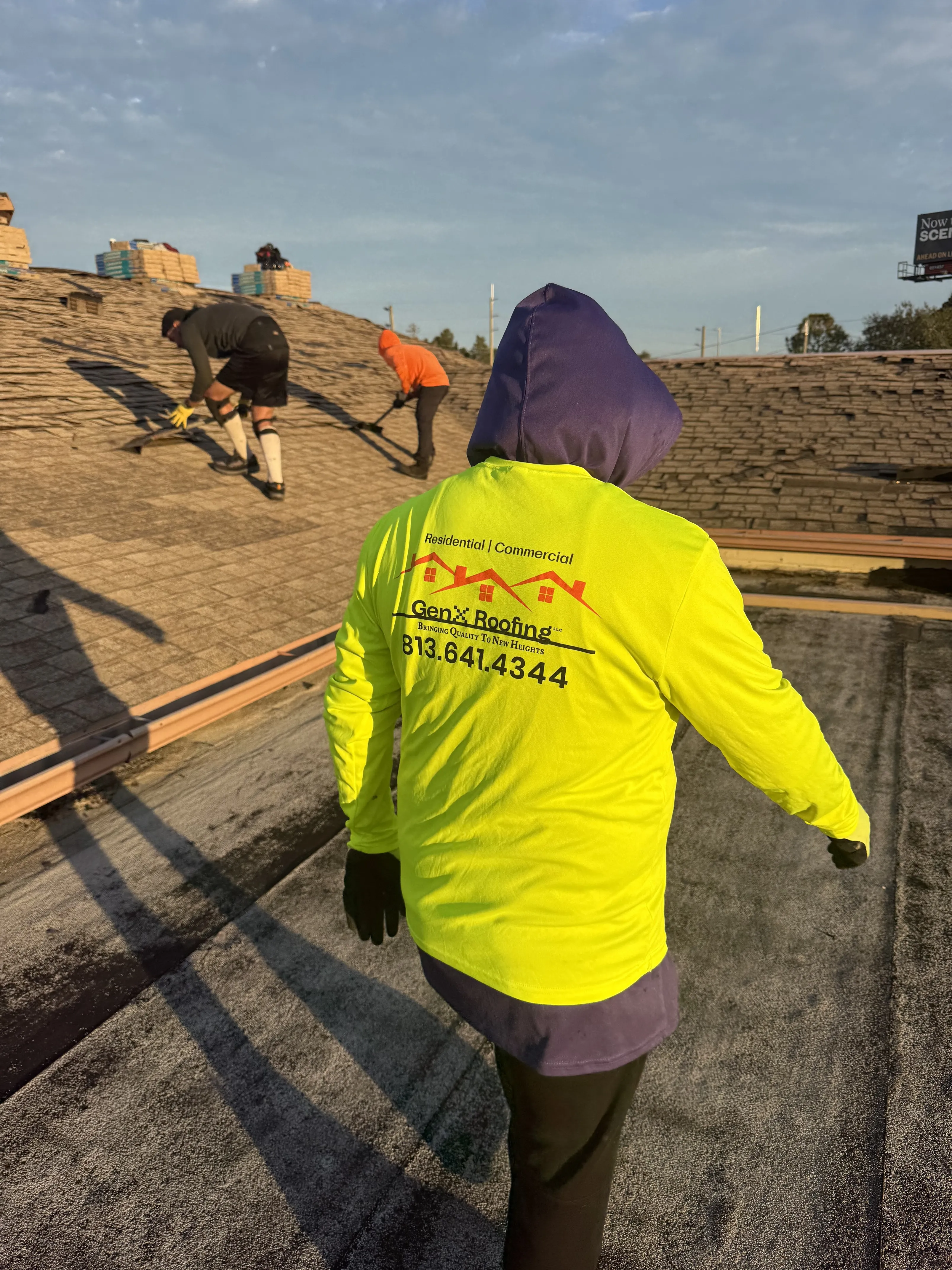 GenX Roofing crew installing shingles on residential property
