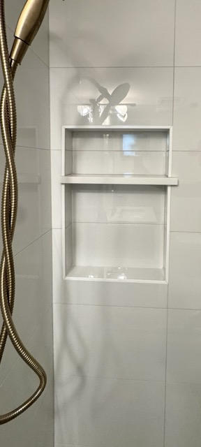 ### Key Elements - **Main Subjects**: Shower niche, showerhead - **Objects**: White tiled wall, two