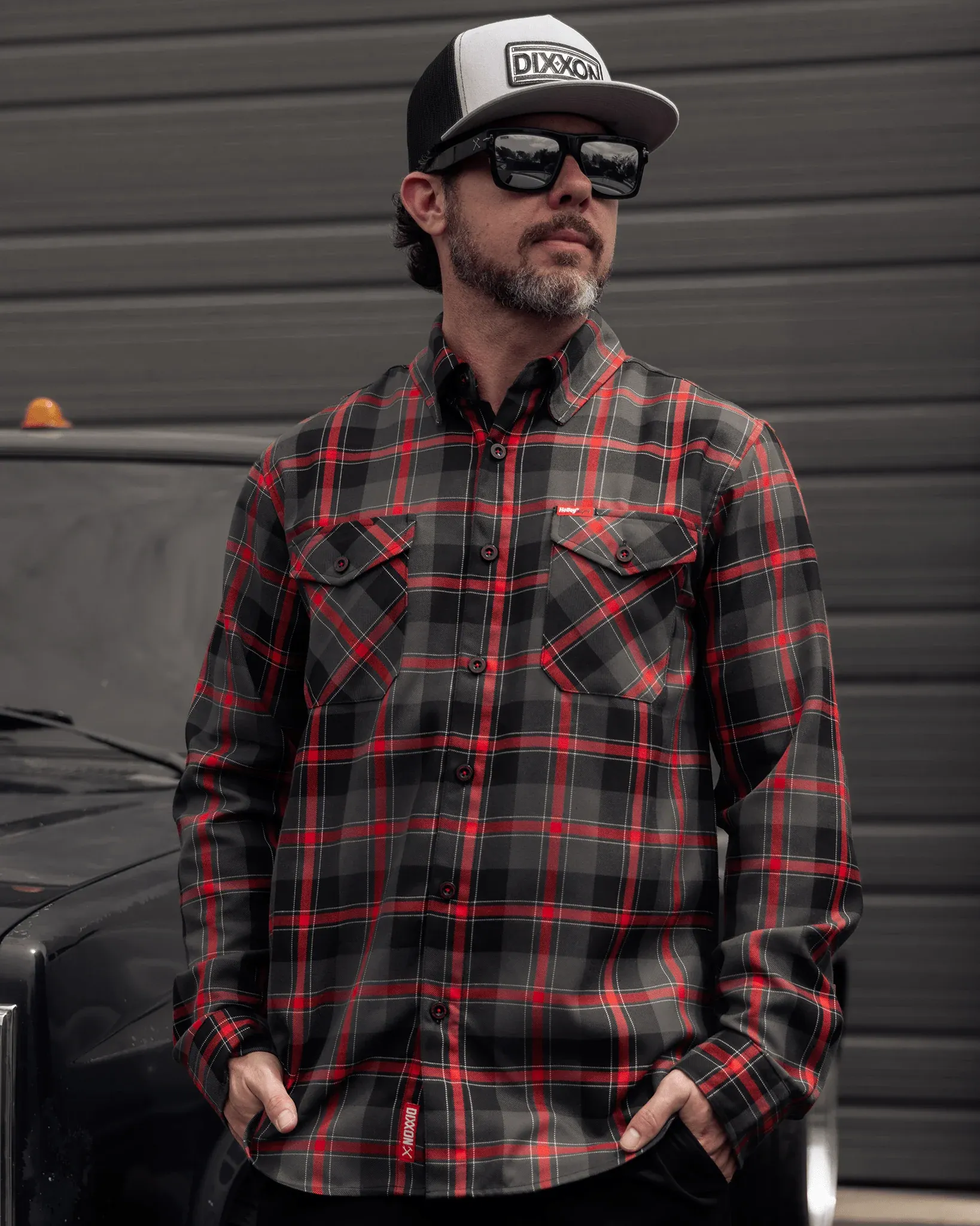 Rider wearing a black and red Holley EFI x Dixxon plaid flannel shirt and a grey Dixxon snapback hat.