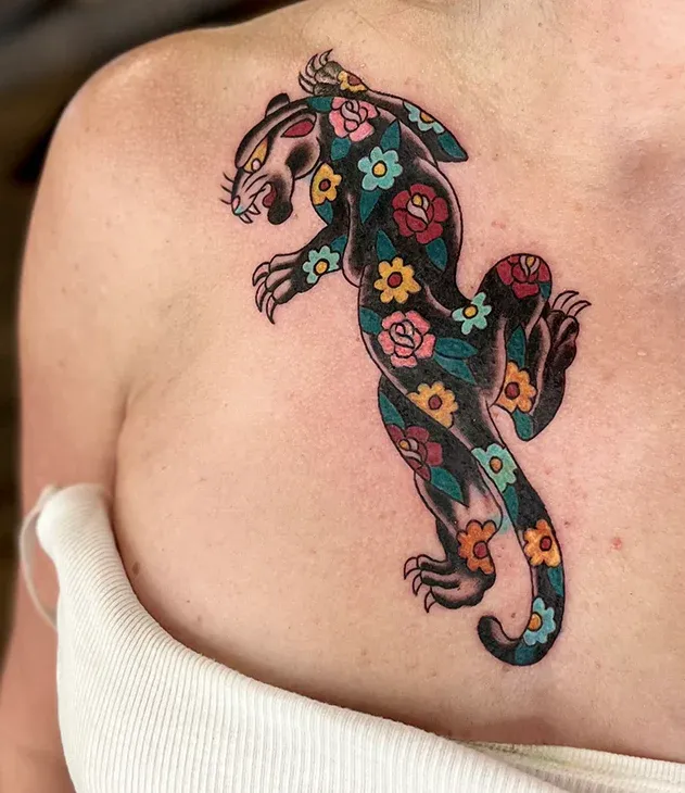 American traditional chest tattoo of a black panther patterned with colorful flowers.