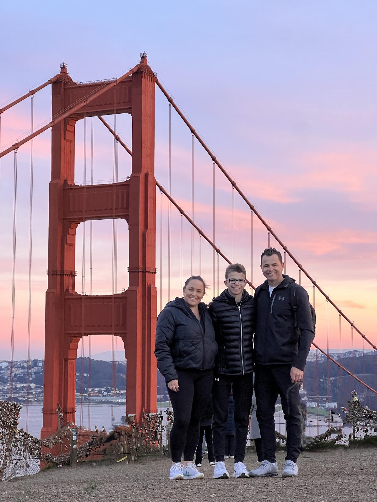Three friends in front of the Golden Gate Bridge at sunset