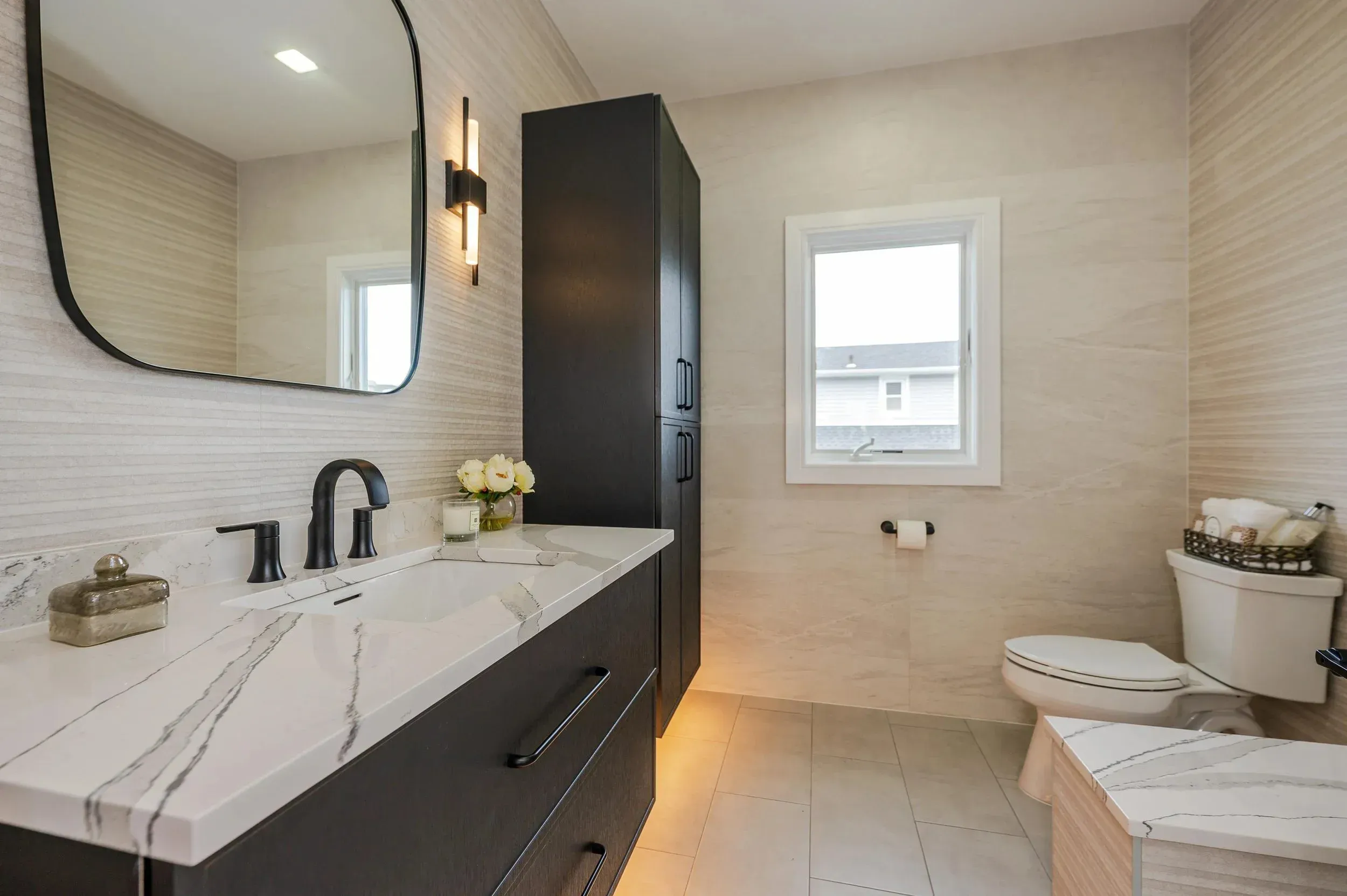 Modern bathroom with a sleek vanity, large mirror, and natural light
