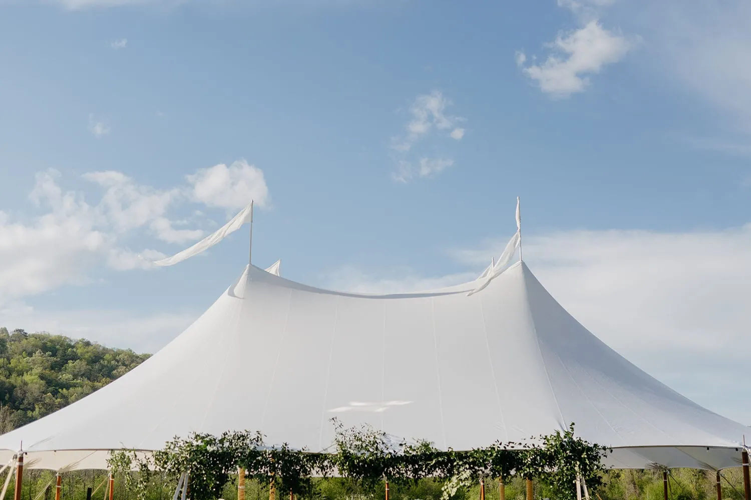 Elegant outdoor reception beneath a classic Century tent during summer