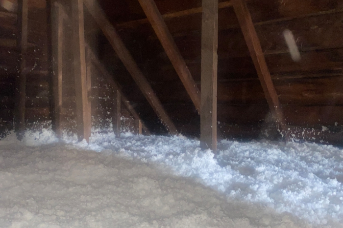 Interior view of a well-insulated attic with blown-in cellulose insulation covering the floor