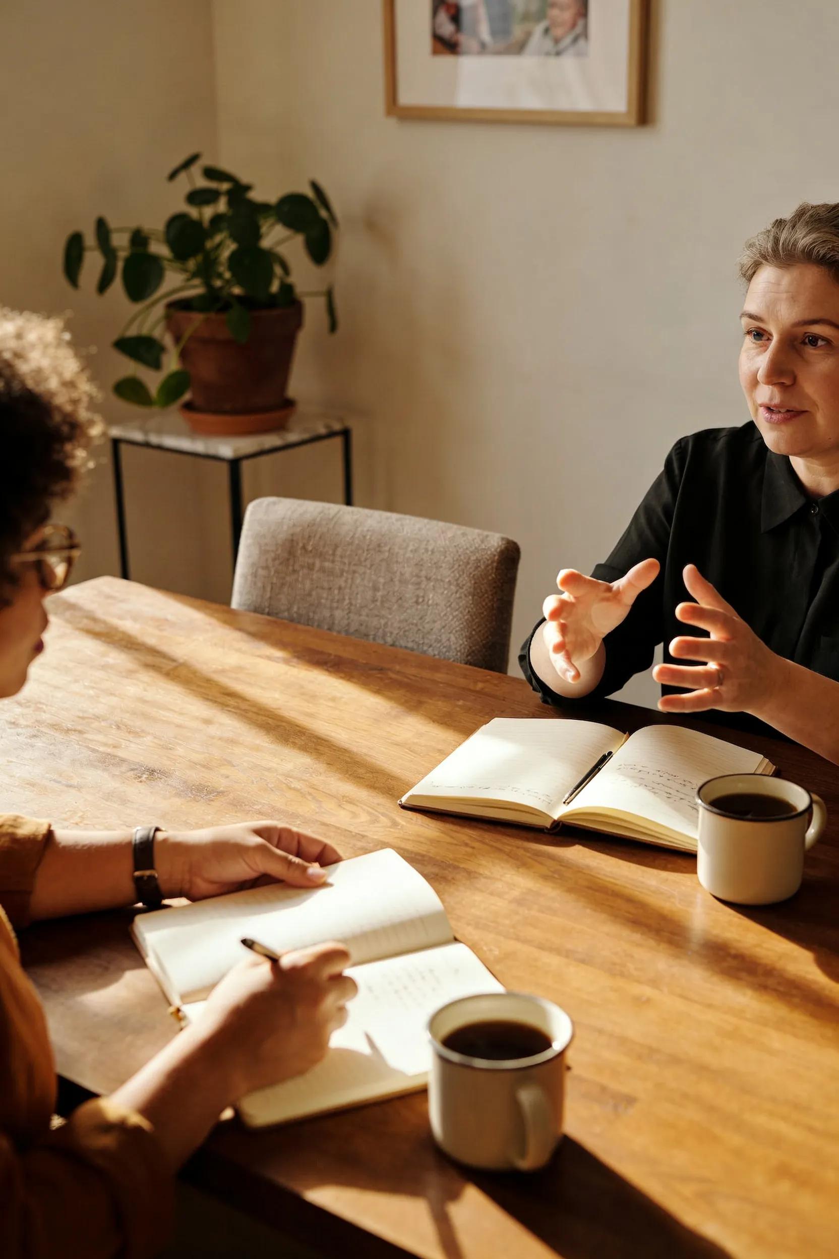 Coach and client discussing personalized coaching strategies in a cozy setting