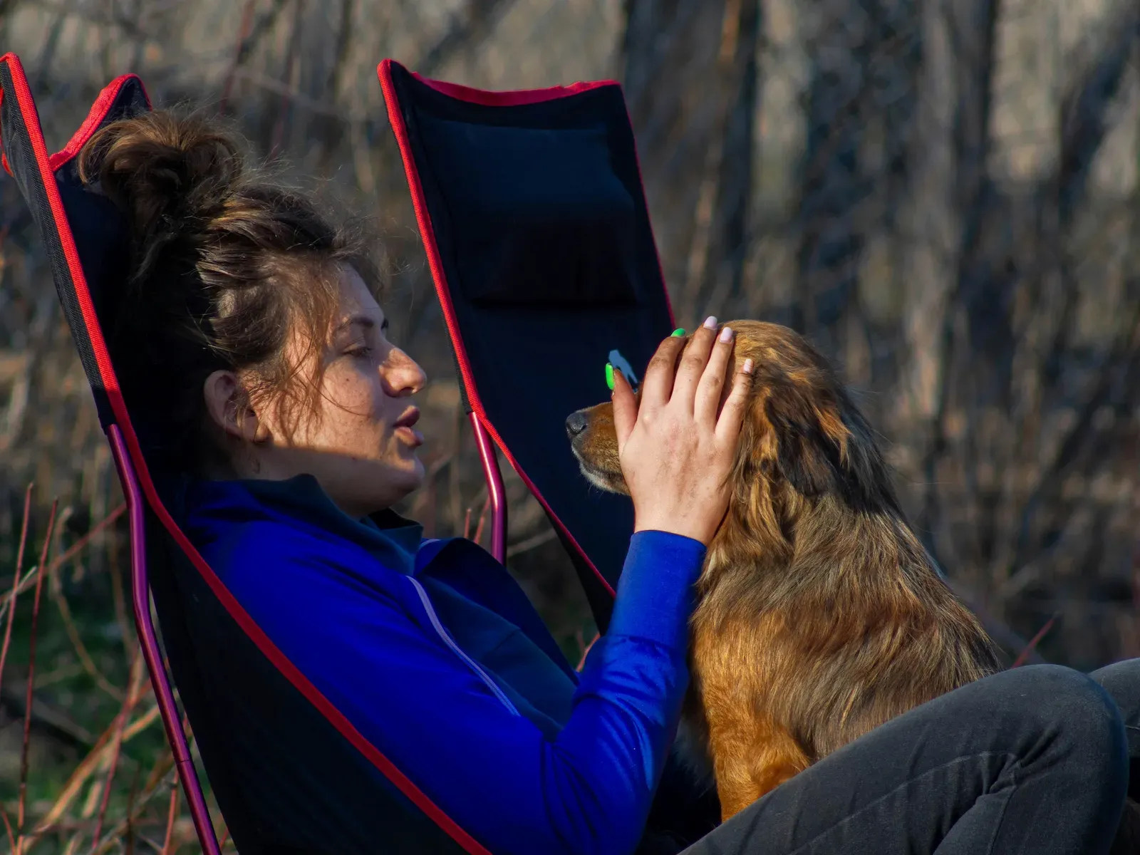 Owner ensuring dog's comfort in a carrier backpack before hiking