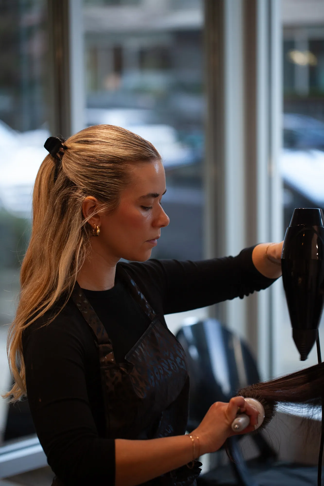 Stylist blow-drying a client's hair in a Vancouver salon