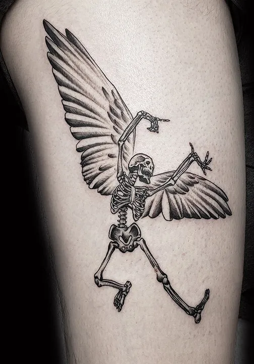 Fine-line black-and-grey tattoo of a winged skeleton dynamically posing.