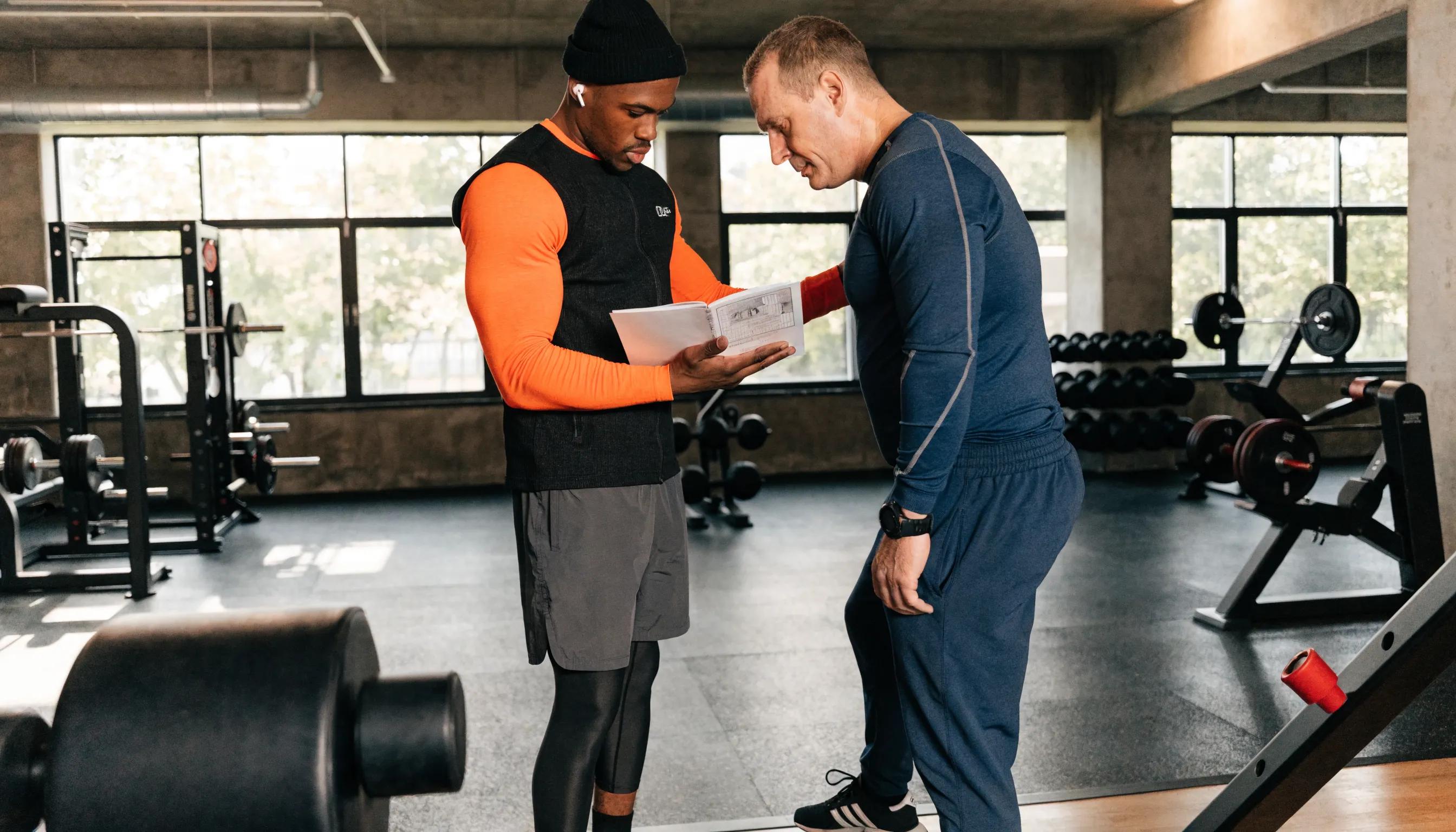A personal trainer guiding a client through a customised exercise plan, showcasing the individualized approach to injury recovery.