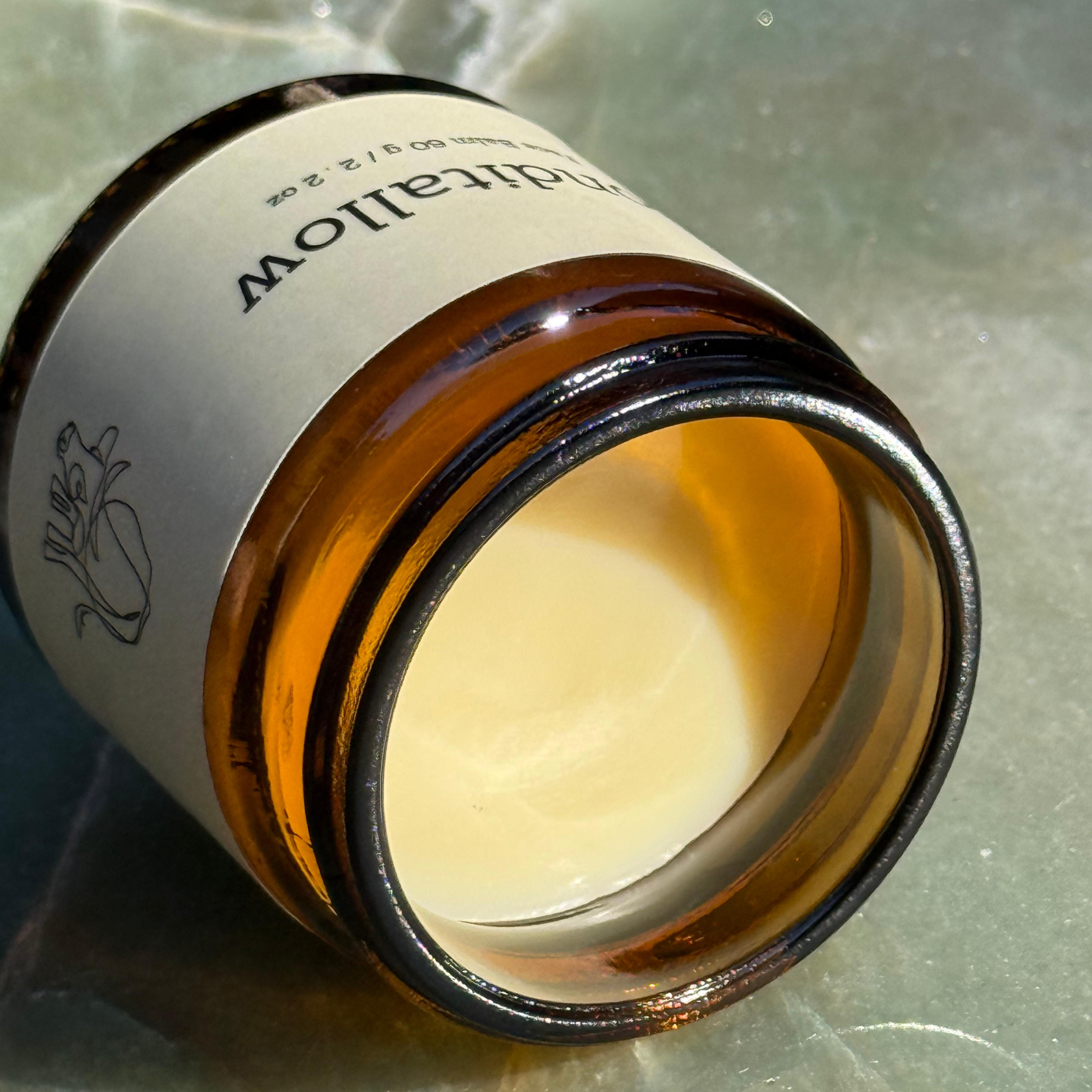 Amber glass jar with a white cream inside and a printed label