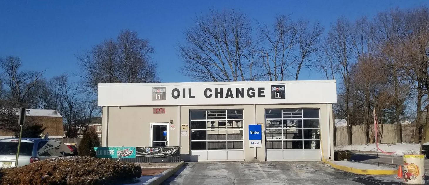 Customer speaking with staff at a lube center about a walk-in oil change, showing quick service options