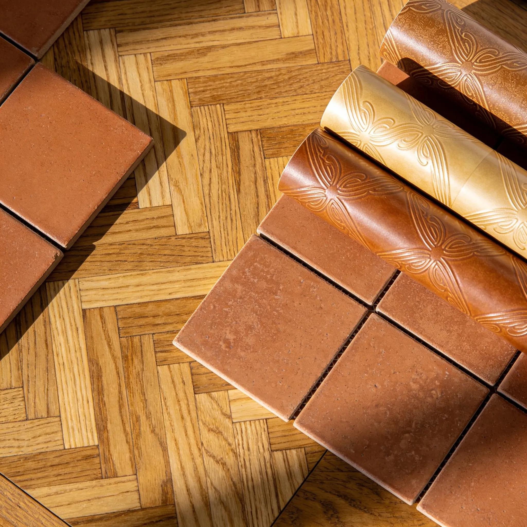 Comparison of classic floors: herringbone wood, terracotta tile, and refined vinyl, highlighting texture and variety.